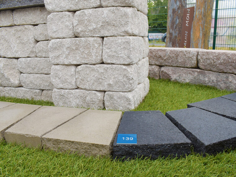 Mauersteine und Terrassenplatten auf Rasen