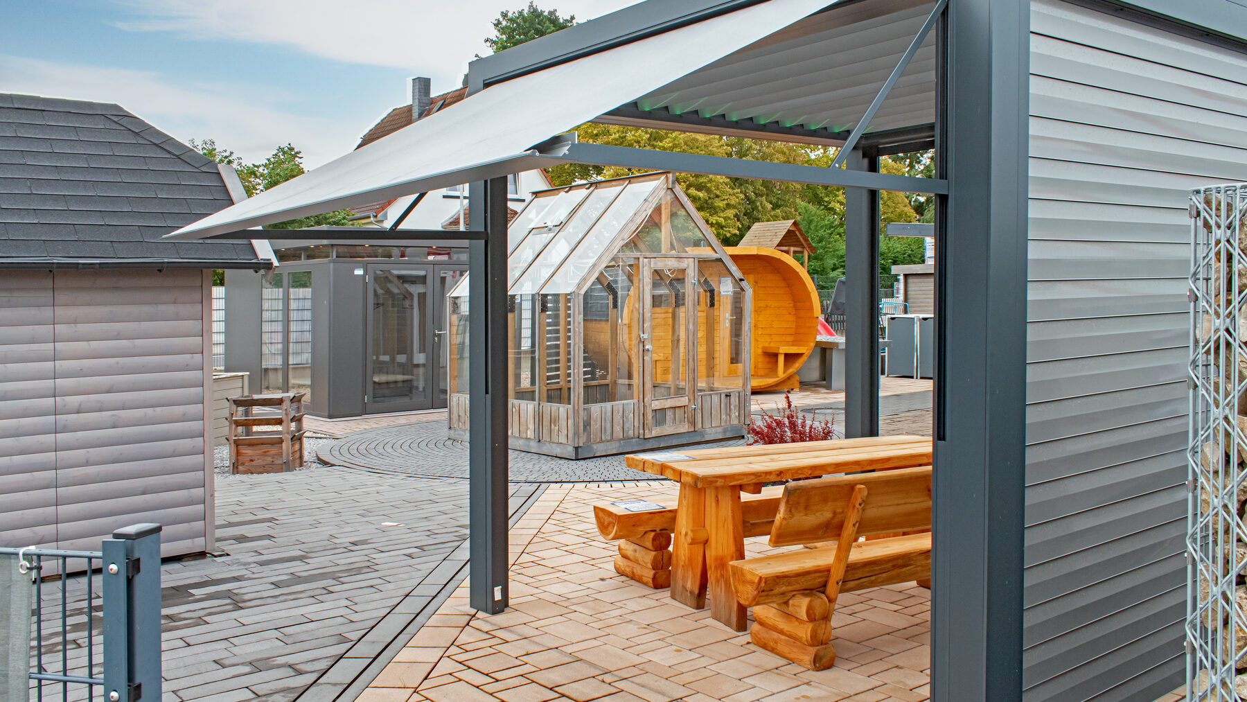 Ideengarten mit Pergola, Holztisch und Gewächshaus bei Andre + Oestreicher